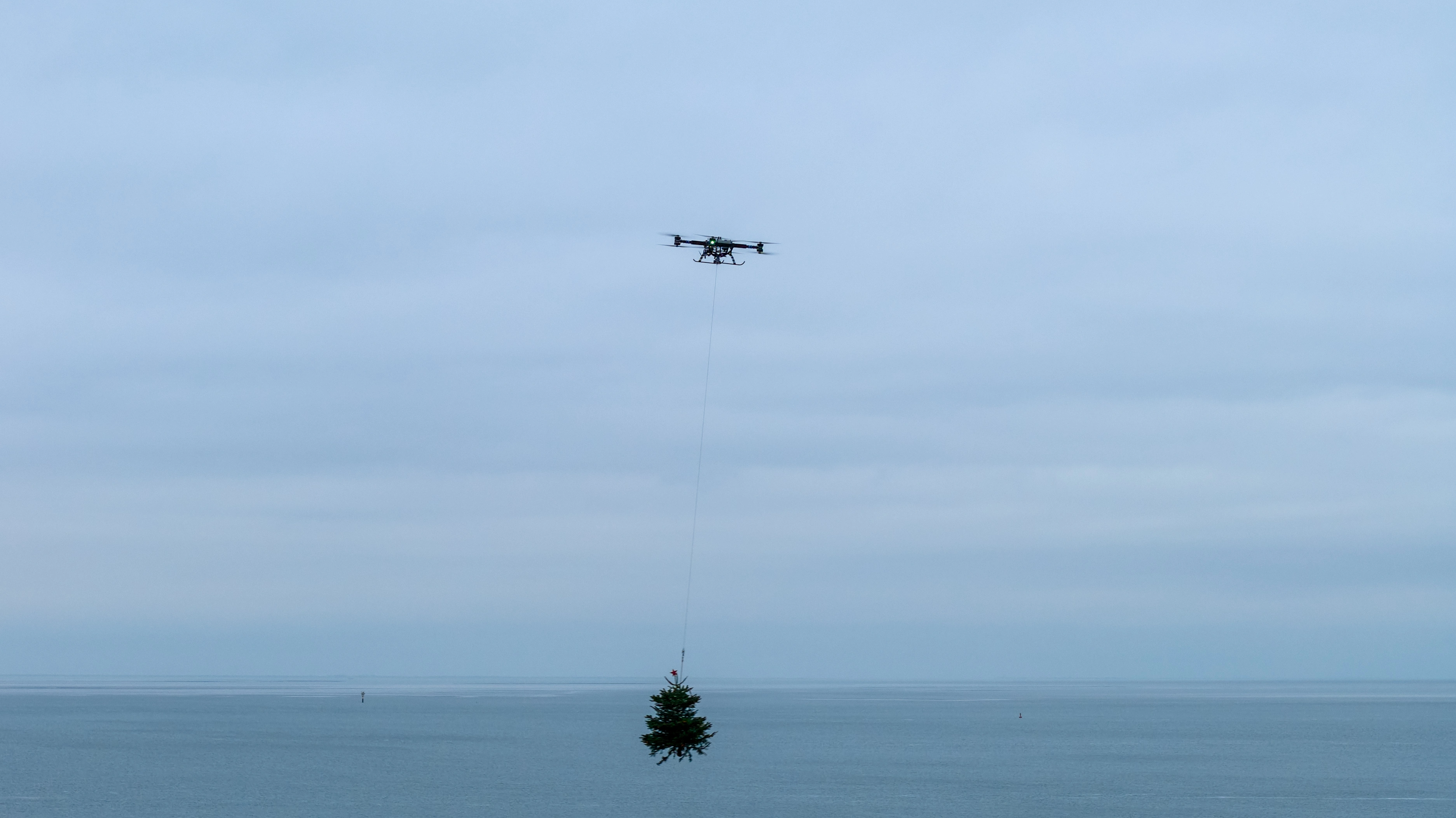 Drone met kerstboom boven zee